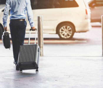 Businessmen leave with baggage at the airport.Focus on luggage.